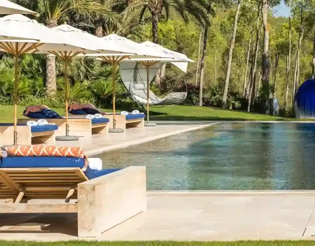 Luxury villa in Ibiza with a large swimming pool and comfortable sofas next to the pool.