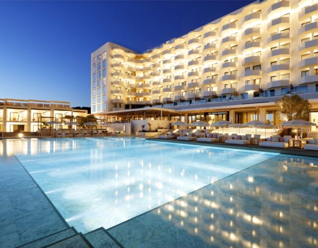 lighted pool with hotel in Ibiza in early night sky