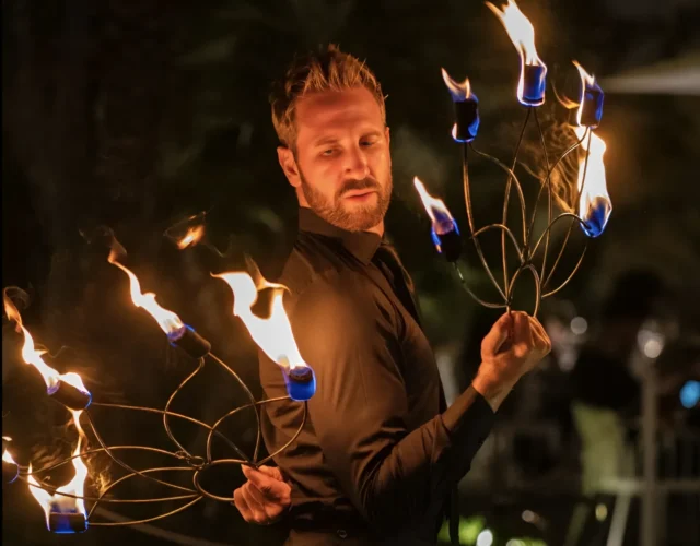 A man skillfully manipulates fire sticks, showcasing a captivating display of fire artistry.