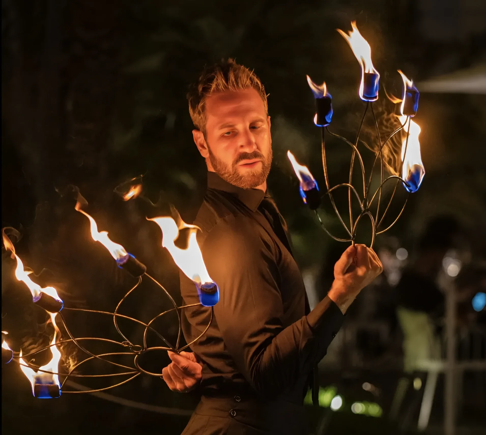A man skillfully manipulates fire sticks, showcasing a captivating display of fire artistry.