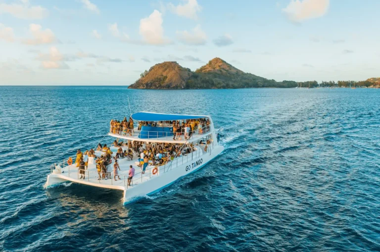 A group of people enjoys a yacht party on the ocean, surrounded by water and distant horizons.